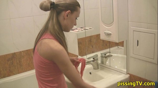 Женщина писает на унитазе в туалете